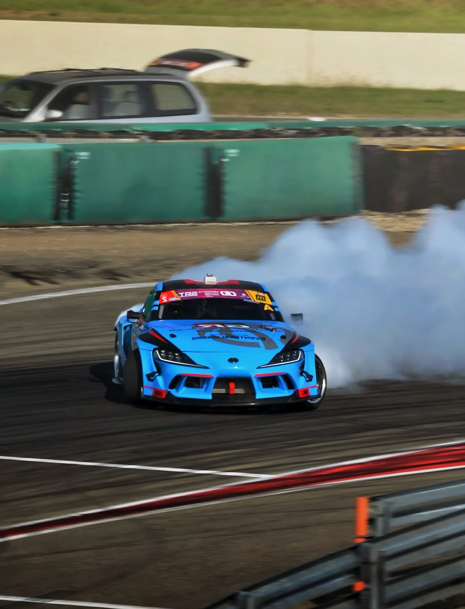Blue drift car throwing up tyre smoke on a race track