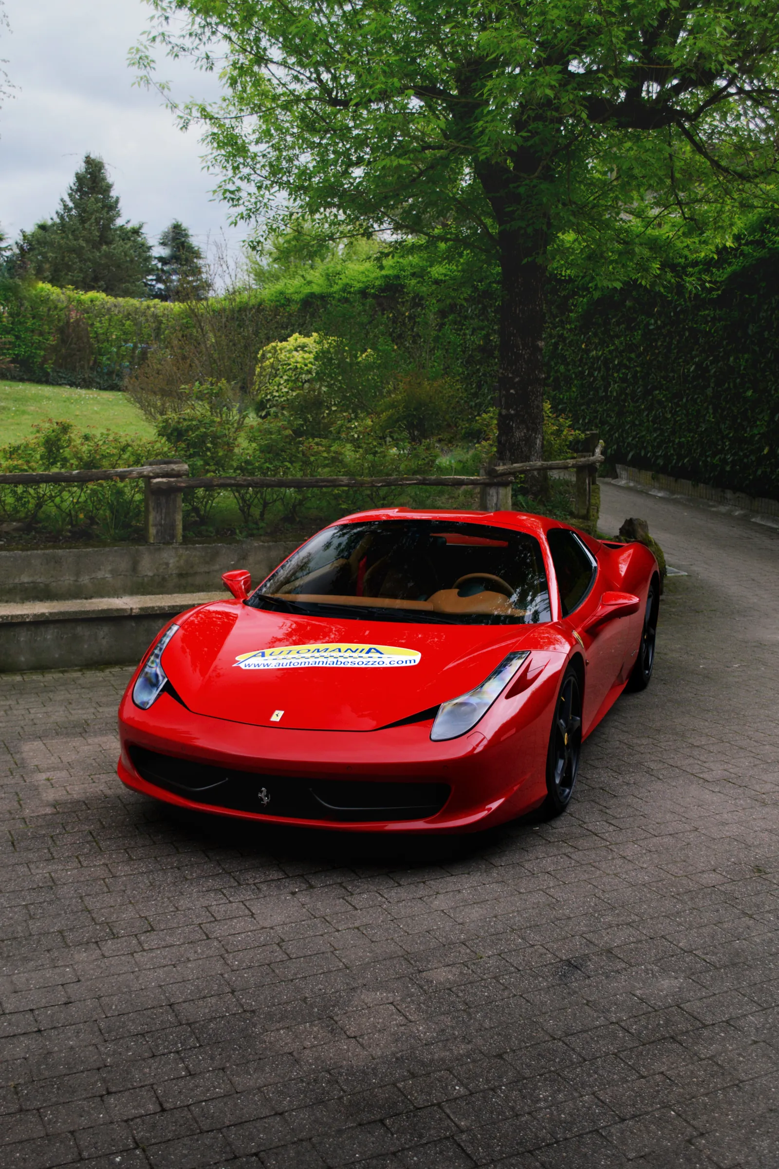 Red Ferrari 458 Spider on a cobbled drive